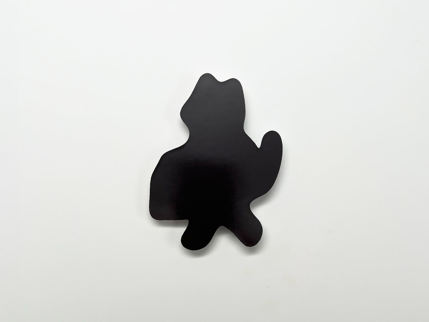 ChatGPT said:
Back view of a handmade die-cut magnet shaped like a standing cat with a raised tail. The solid black magnetic surface is shown against a plain white background.