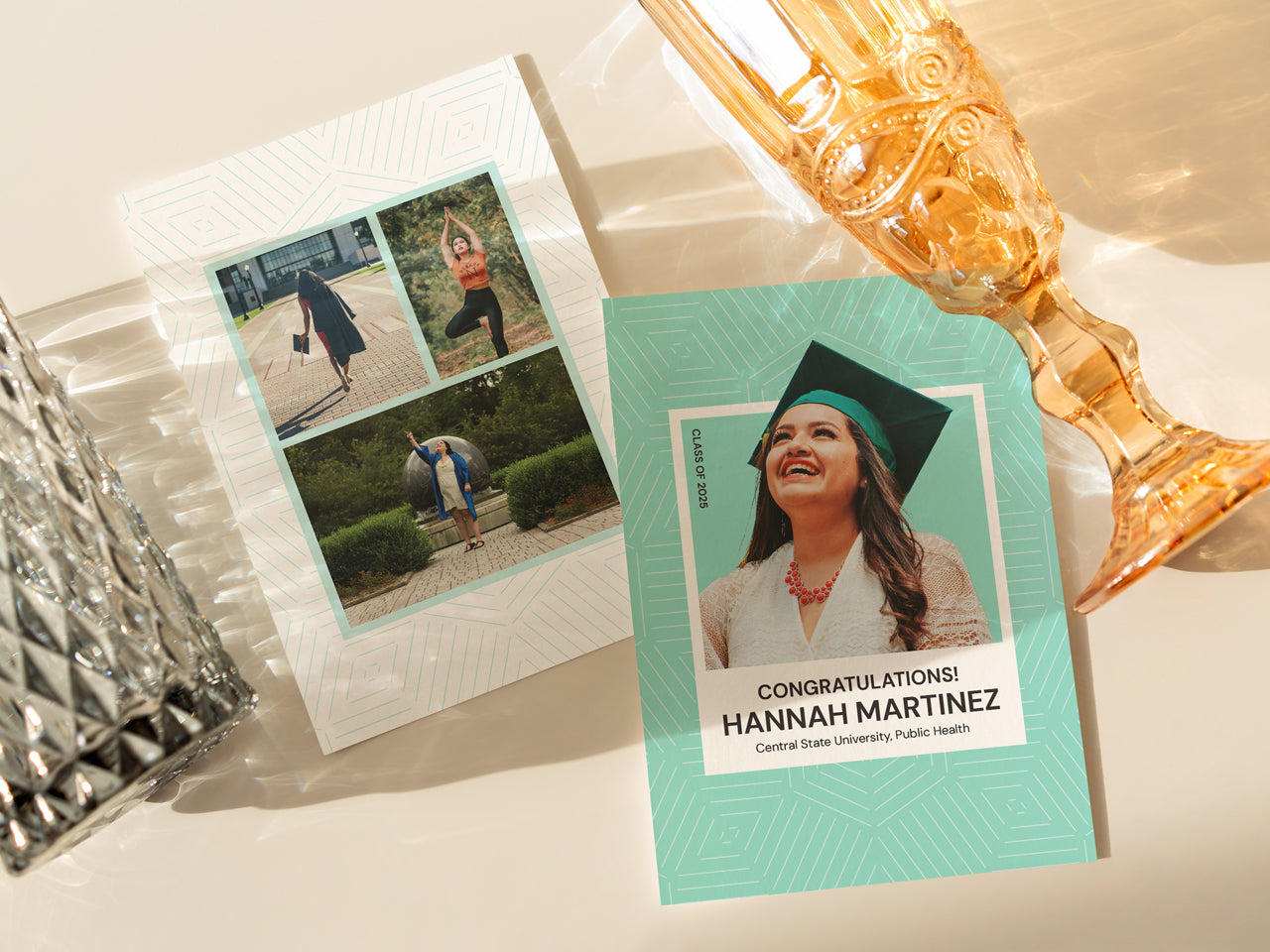 A modern, double-sided graduation announcement card set with a geometric mint green background. The front features a large portrait of a smiling graduate wearing a cap and gown, while the back showcases a collage of three personal photos. The card is printed on high-quality white cotton cover paper. It is displayed on a textured neutral surface with a natural wooden accent, adding warmth to the composition.