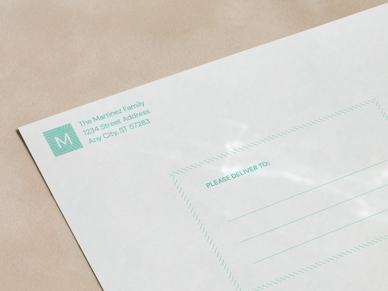 A personalized white envelope with a matching mint green geometric design and printed return address in an elegant font. The envelope includes a pre-designed recipient address section, making it easy to send announcements. The high-quality paper complements the graduation announcement card set. The envelope is placed on a smooth, light-reflective surface, capturing soft shadows and highlights that emphasize its premium feel.