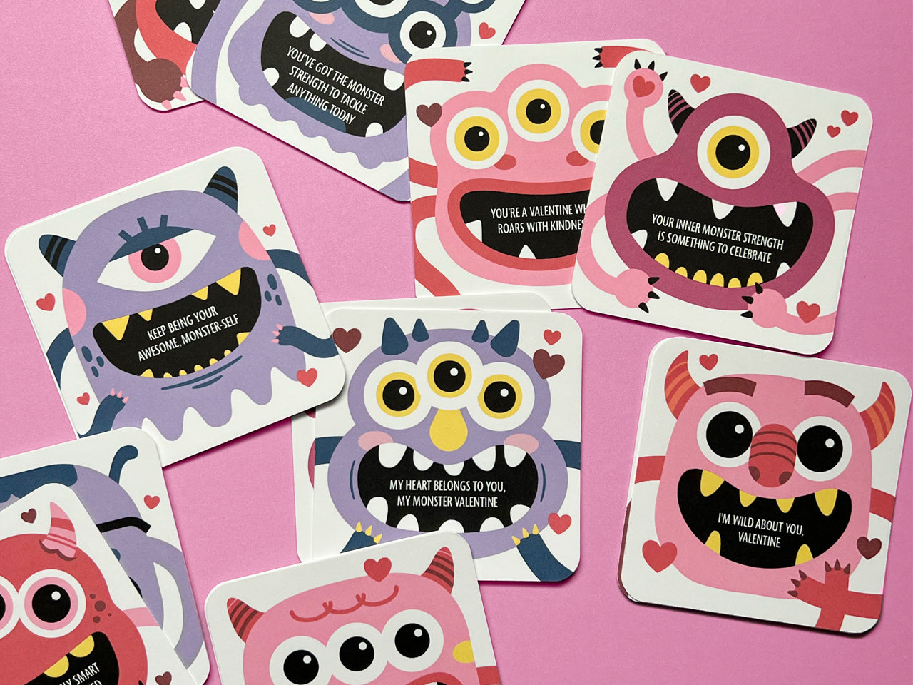 A playful arrangement of colorful monster-themed Valentine lunch box notes spread out on a pink background. Each card features unique monster illustrations with heartwarming messages. These notes are perfect for kids and Valentine’s Day exchanges.