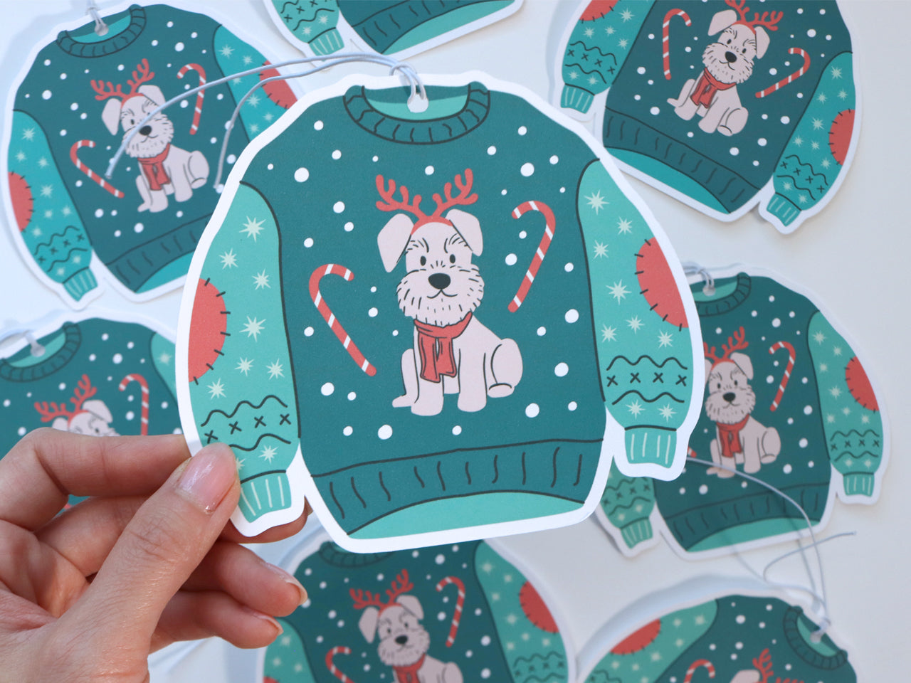 The front and back of a Christmas sweater gift tag, showcasing both the fun dog illustration on the sweater and the space for a personalized message on the back. A white string is attached for easy use.