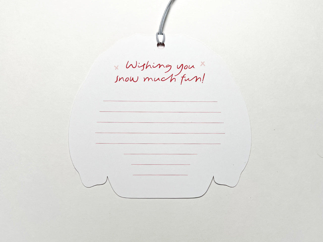 Back view of a Christmas sweater-shaped gift tag with a lined space for writing a personalized message. At the top, in festive red script, it says "Wishing you snow much fun!" with small snowflake accents. The tag is attached to a white string, ready to be used for holiday gift wrapping.
