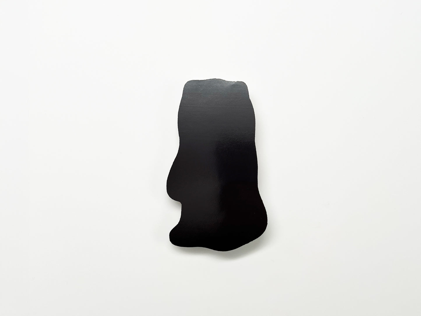 Back view of a handmade die-cut Bigfoot Halloween magnet, showing the smooth black magnetic surface. Durable fridge magnet perfect for holding notes or photos, ideal for Halloween décor, cryptid enthusiasts, and quirky woodland creature gifts.