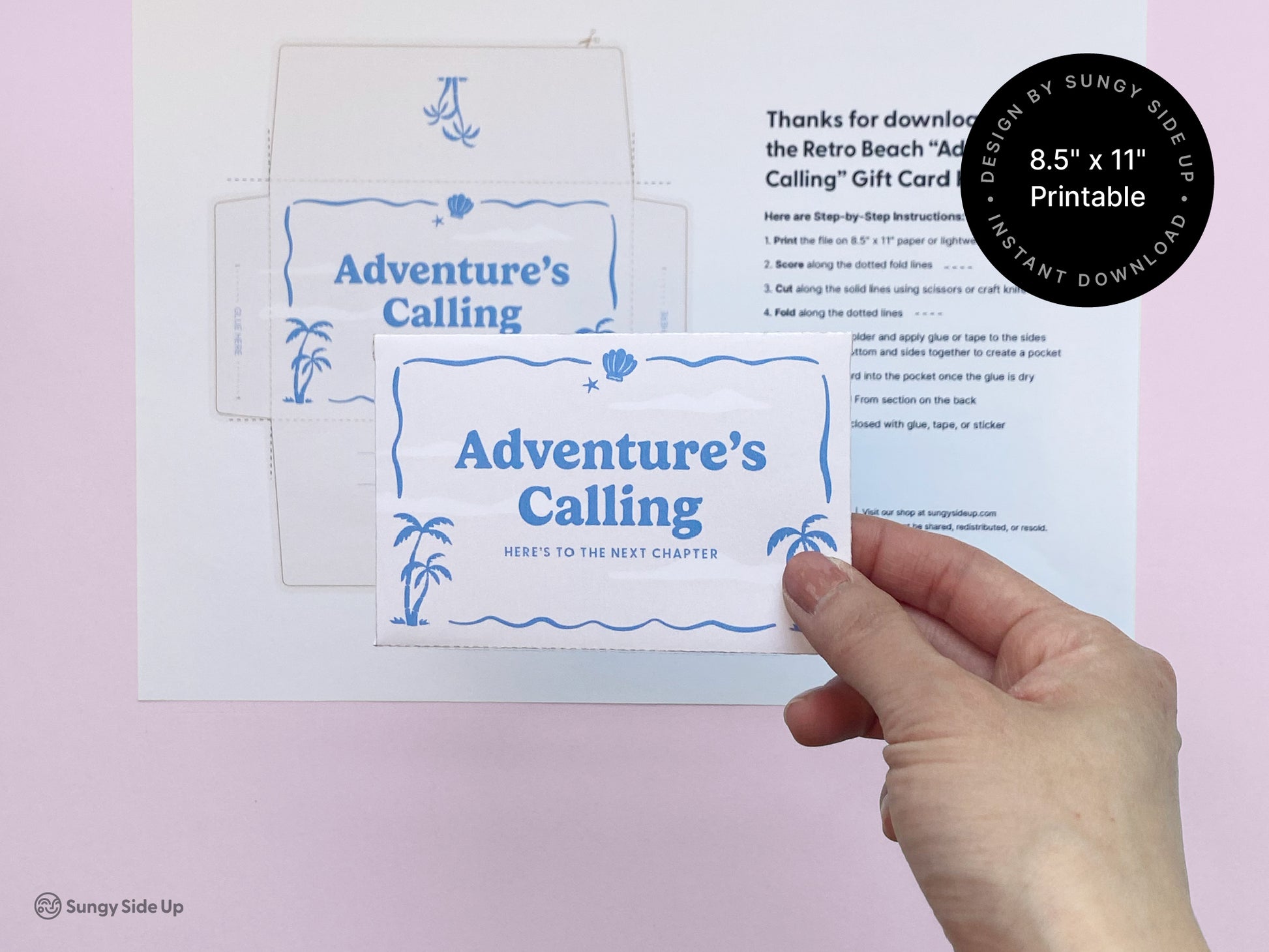 Hand holding a completed retro beach-themed printable gift card holder that says “Adventure’s Calling,” featuring palm trees and waves in blue. The background shows the full 8.5" x 11" print template and assembly instructions on white paper against a soft pink surface. Ideal for gifting occasions like travel, graduation, or farewell. This digital download provides a creative and nostalgic way to present gift cards, combining DIY charm with a summer-inspired design.