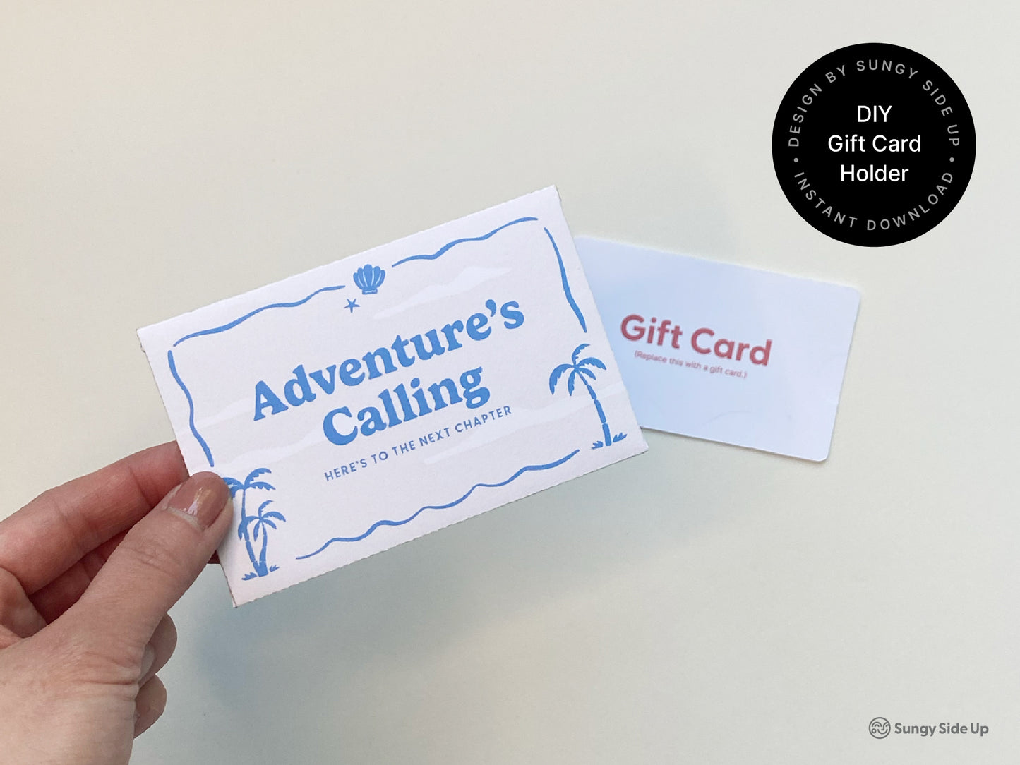 Close-up image of a hand holding a retro beach-themed printable gift card holder that reads “Adventure’s Calling” with palm tree and wave illustrations. A mock gift card lies nearby on a light cream background, showing the scale and intended use of the DIY envelope. The design is ideal for vacations, graduations, retirement, or travel-themed gifting. This digital download offers a creative and fun way to give gift cards with a handmade, nostalgic touch. Perfect for personal use or celebration.