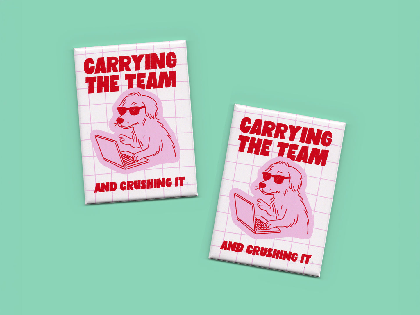 Two rectangular magnets displayed on a mint green background featuring bold red text that says “Carrying the Team and Crushing It” with a pink illustration of a dog wearing sunglasses while working on a laptop over a light pink grid pattern.