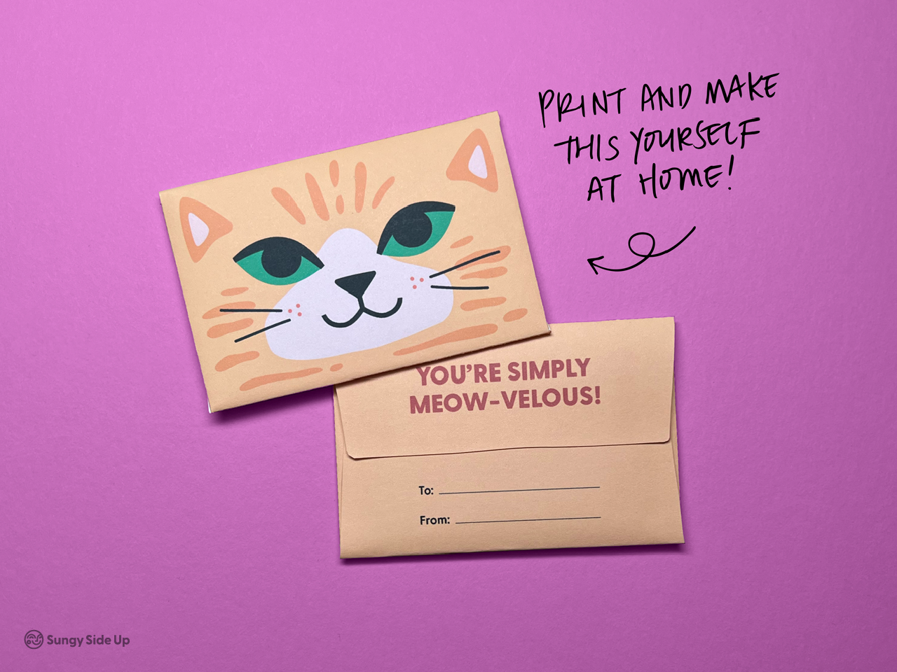 Two assembled cat-themed gift card holders are shown on a bright pink background. One reveals the front with a cute orange tabby face, while the other is flipped to display the back with “You’re Simply Meow-velous!” and blank “To” and “From” lines. Handwritten text says, “Print and make this yourself at home.” This image captures the finished look of the printable and its fun, gift-ready design. Ideal for DIY gifting.