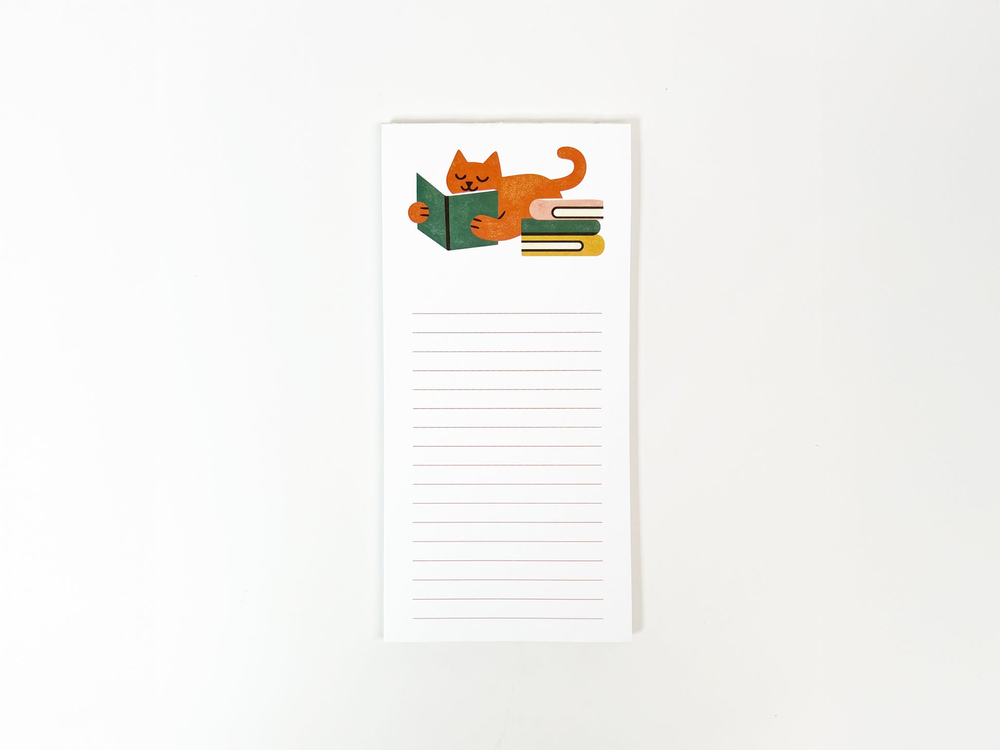 Tall, slim lined notepad featuring a cozy illustration of an orange cat lying down and reading a green book beside a small stack of books, with blank lined space below for notes on a white background.