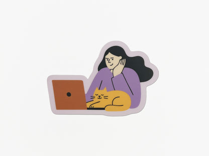Matte vinyl die-cut sticker on a white background showing an illustration of a person with long dark hair wearing a lavender top, resting their head on one hand while looking at an orange laptop. A yellow cat with closed eyes is stretched out in front of the laptop, appearing relaxed. The sticker has a soft lavender border around the illustration.