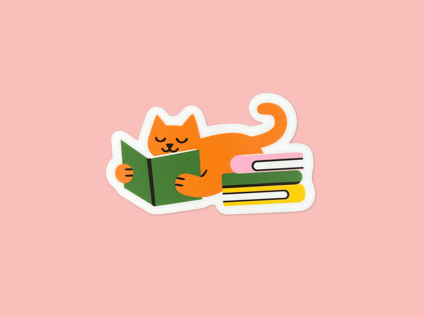 Matte vinyl die cut sticker of an orange cat lying on its belly while reading a green book, with a curled tail and a colorful stack of books beside it. The sticker has a white border and is shown centered on a soft pink background. Cute reading cat sticker for book lovers and cat lovers, made from water- and fade-resistant vinyl.