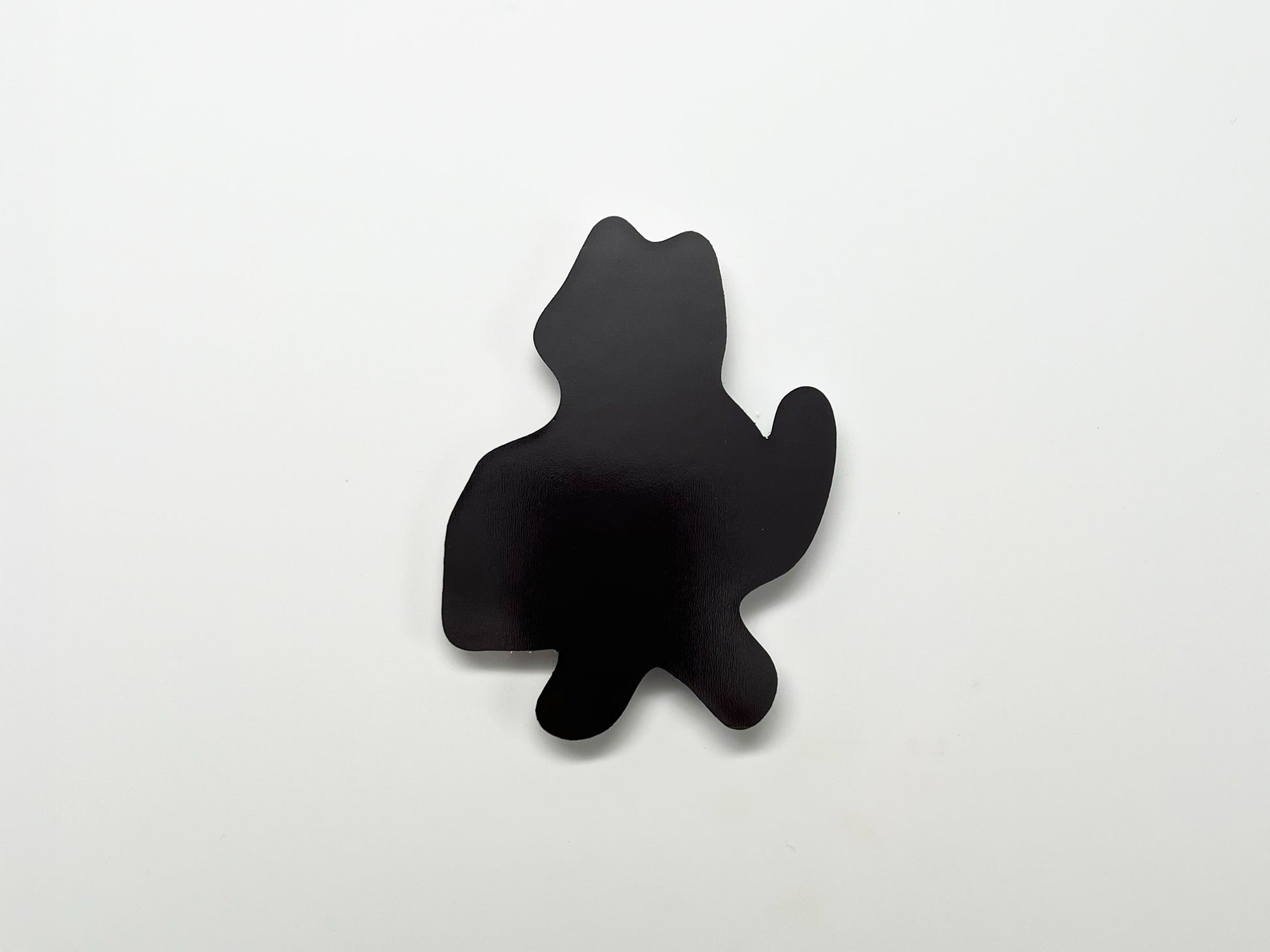 ChatGPT said:

Back view of a handmade die-cut magnet shaped like a standing cat with a raised tail. The solid black magnetic surface is shown against a plain white background.
