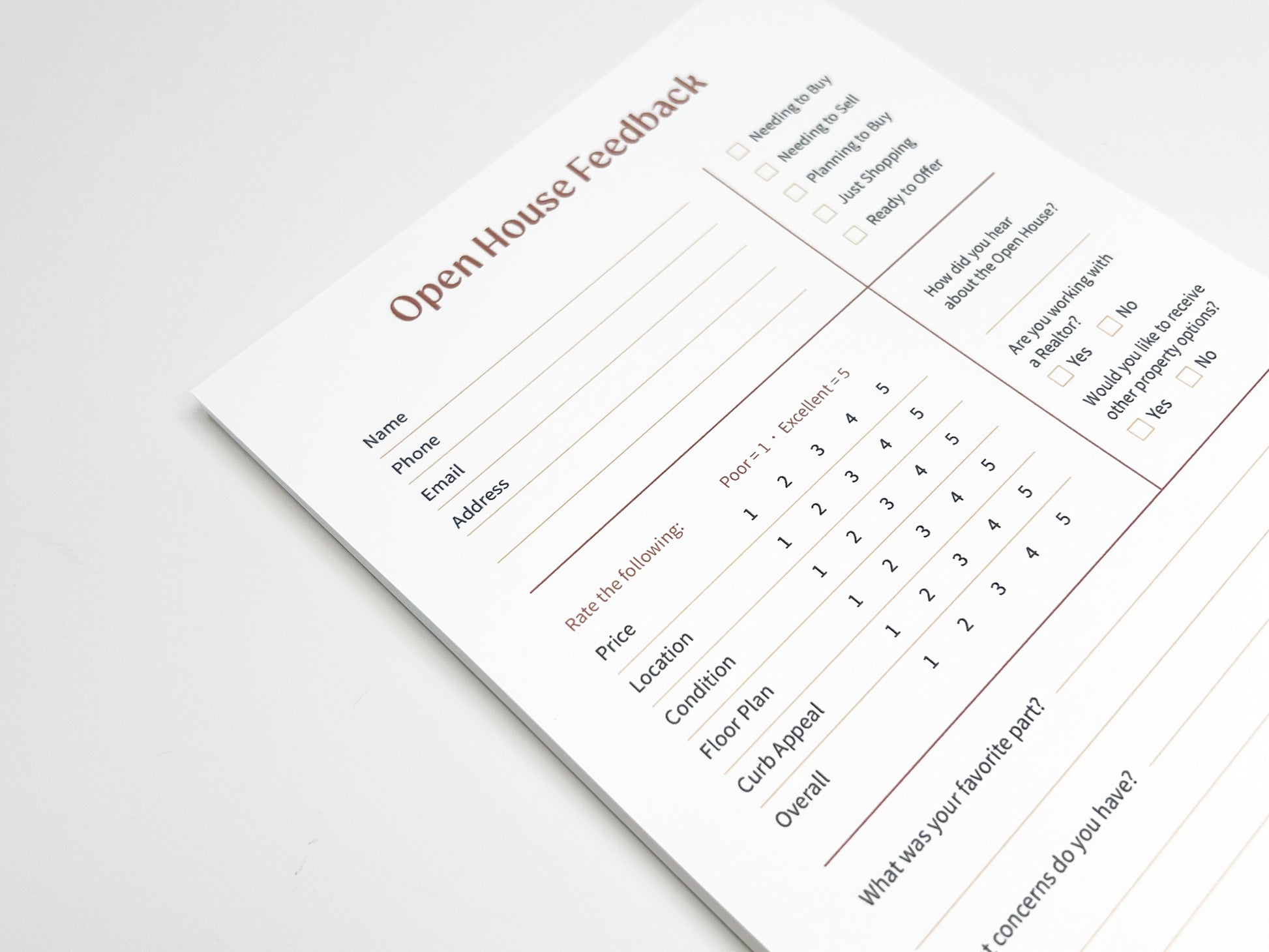 Angled close-up of a custom 5 × 8 Open House Feedback real estate notepad showing structured sections for buyer contact details, purchase readiness checkboxes, property rating scales for price, location, condition, floor plan and curb appeal, plus open-ended feedback fields designed for real estate open house follow-up.