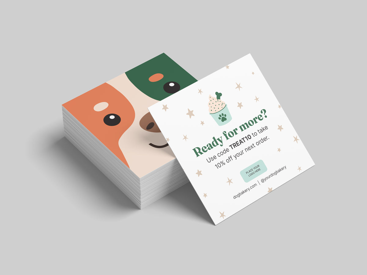Stack of square dog bakery reorder cards featuring an orange, green, and cream illustrated dog face, with an editable “Ready for more?” discount and reorder card displayed in front.