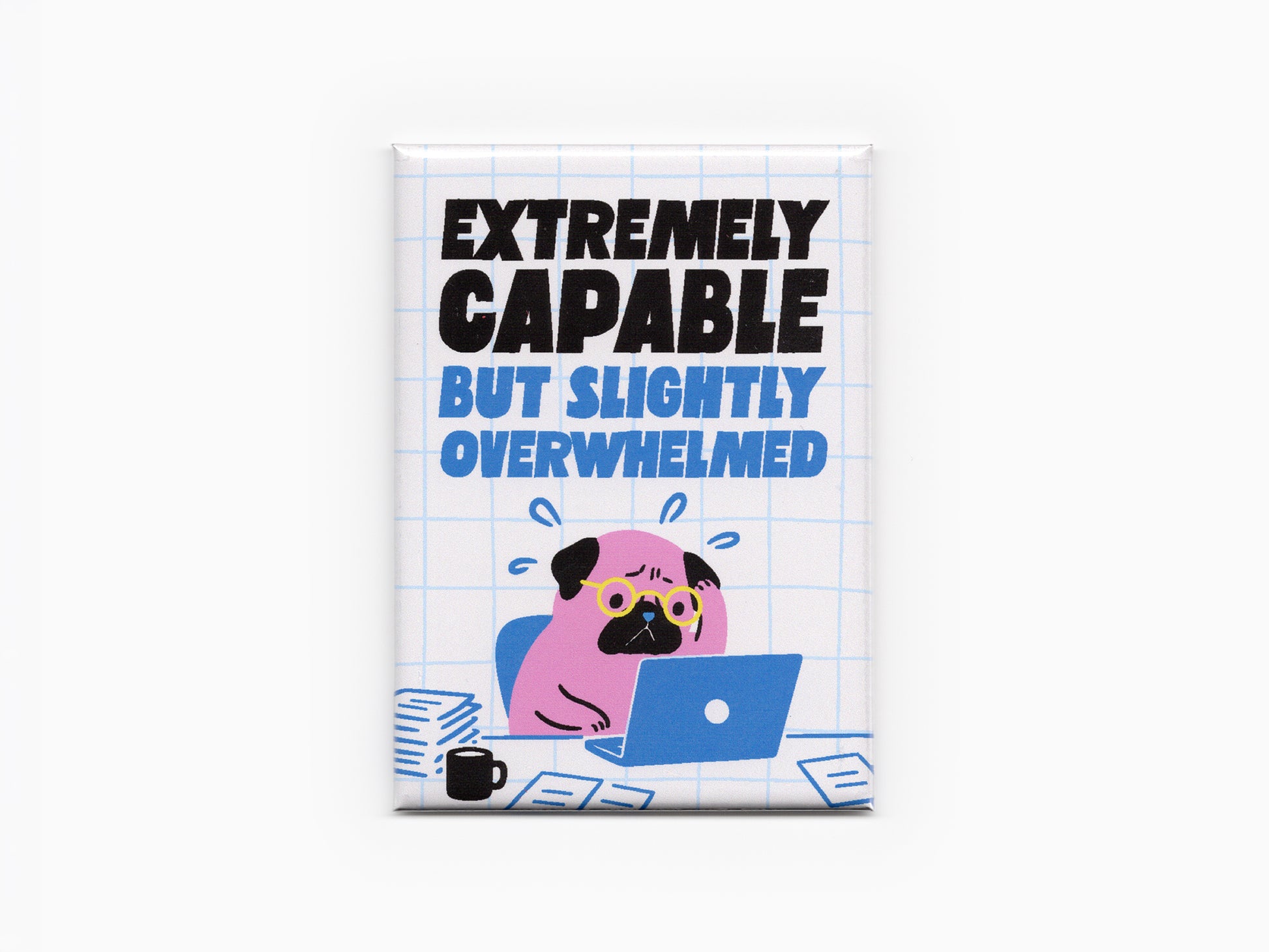 Rectangular magnet with bold black and blue text reading “Extremely Capable But Slightly Overwhelmed” above an illustration of a stressed pink pug wearing glasses while working on a blue laptop. The design includes papers, a coffee mug, and a light blue grid background against a light gray backdrop.