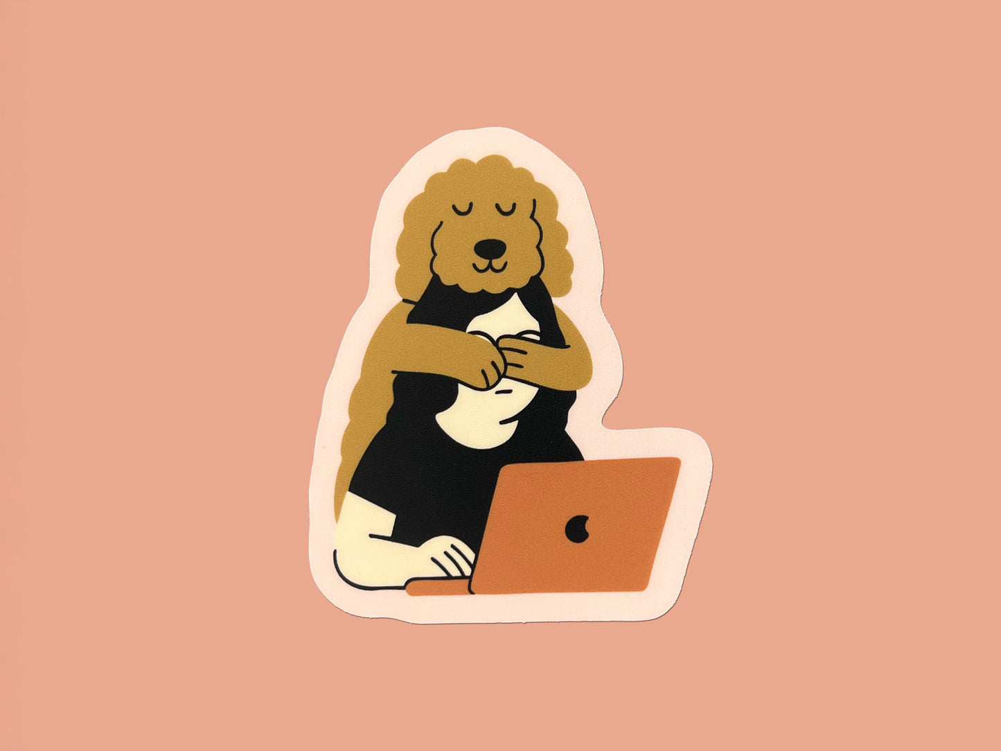 Matte die cut sticker on a peach background showing an illustration of a golden doodle hugging its human from behind while the person works on a laptop. The sticker has a soft pink border and warm neutral colors.