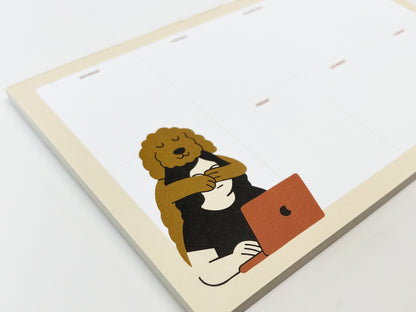 Angled close-up of a weekly planner notepad with a clean Monday–Sunday layout. In the lower corner, a relaxed dog character with curly fur hugs a person sitting at a desk and working on a laptop. The notepad has a soft, neutral color palette and nice paper, shown stacked on a white background.