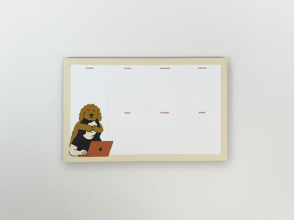 Top-down view of an 8.5 x 5.5 inch weekly planner notepad on a white background. The notepad features a clean Monday–Sunday layout with ample blank space and a playful illustration of a calm, curly-haired dog hugging a person working on a laptop in the lower left corner.
