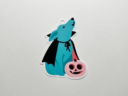 Illustration of a blue vampire dog howling, sitting next to a pink jack-o-lantern.