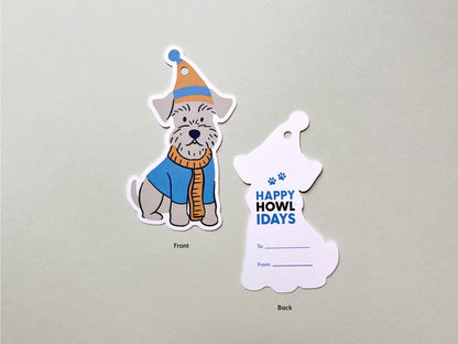 Front and back views of handmade Schnauzer-themed holiday gift tags. The front showcases a cute illustration of a Schnauzer dog in a blue and orange winter hat and scarf, while the back includes the Happy Howlidays greeting with paw print details.