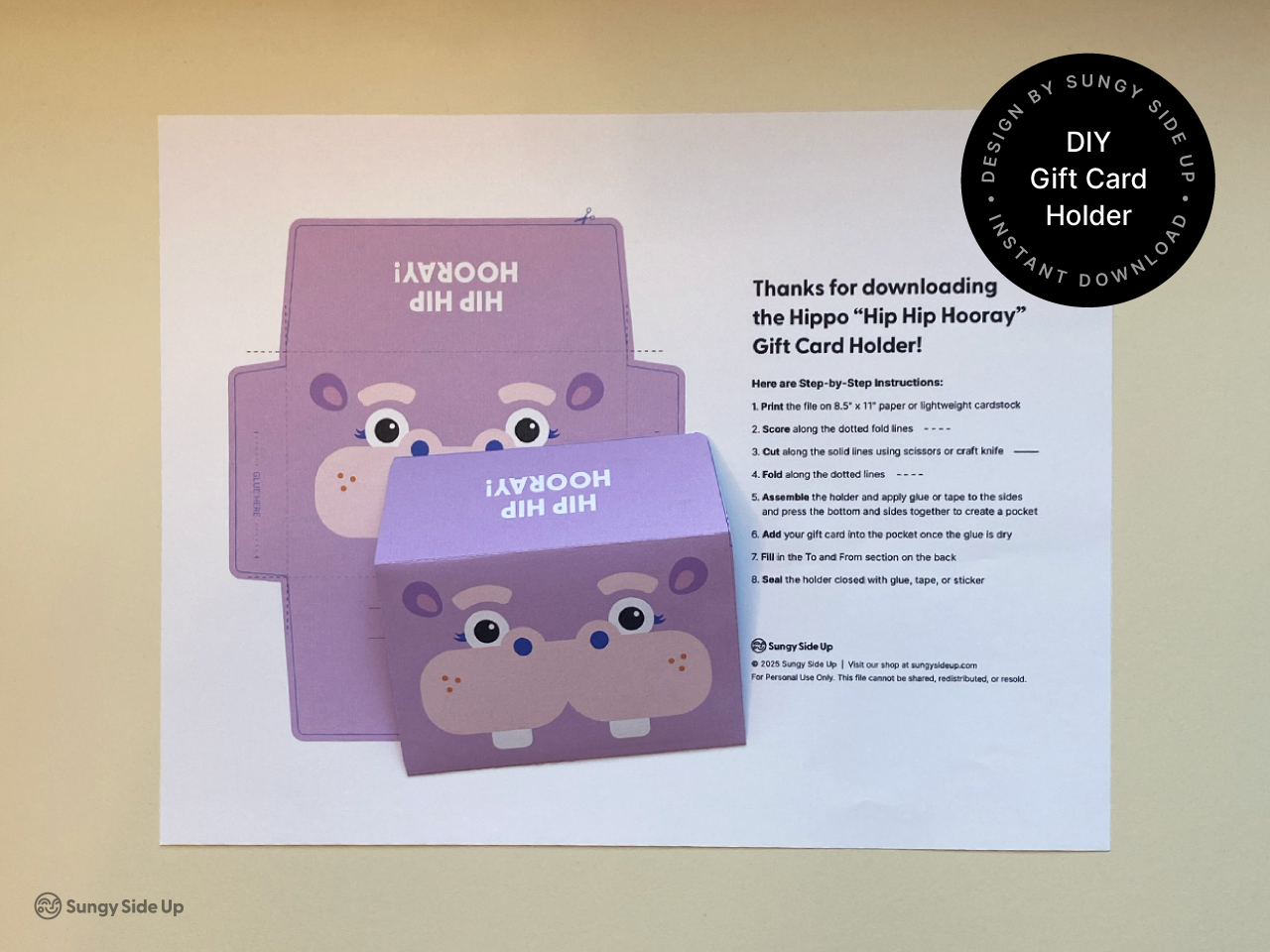 Printed hippo gift card holder template shown alongside a fully assembled envelope. The DIY project is part of a digital download for creating fun birthday or party-themed gift card wraps. Includes instructions to cut, fold, and glue the holder. Great for kids crafts, instant gift ideas, and printable party supplies that are easy to make with a home printer.