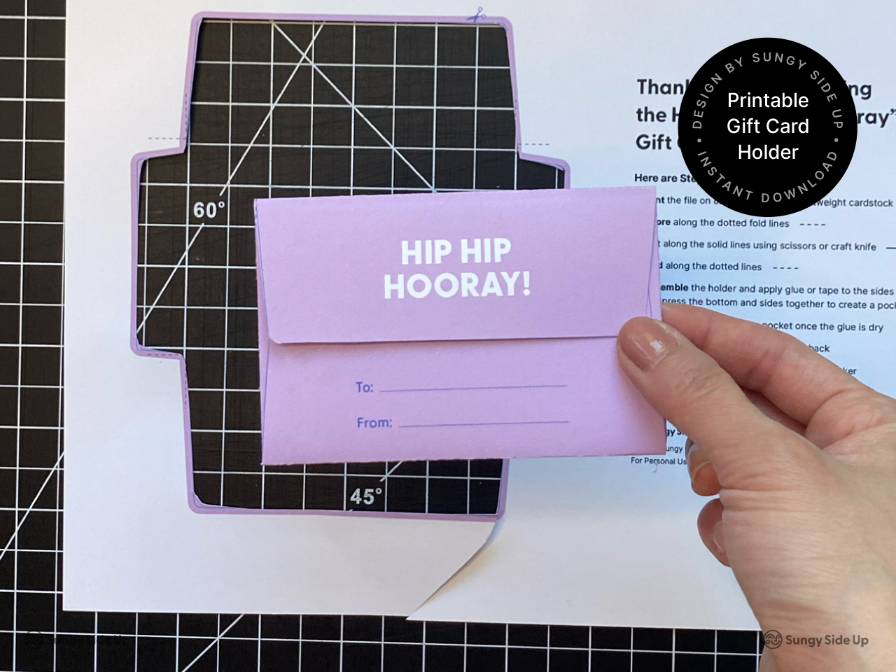 Person holding the back side of a completed printable hippo gift card holder featuring a flap with “To” and “From” lines. This digital download is a DIY paper craft for birthdays, kids gifts, and party favors. Ideal for printing at home and gifting gift cards in a fun and personal way. Great for handmade card alternatives and parents looking for creative gift wrapping ideas.