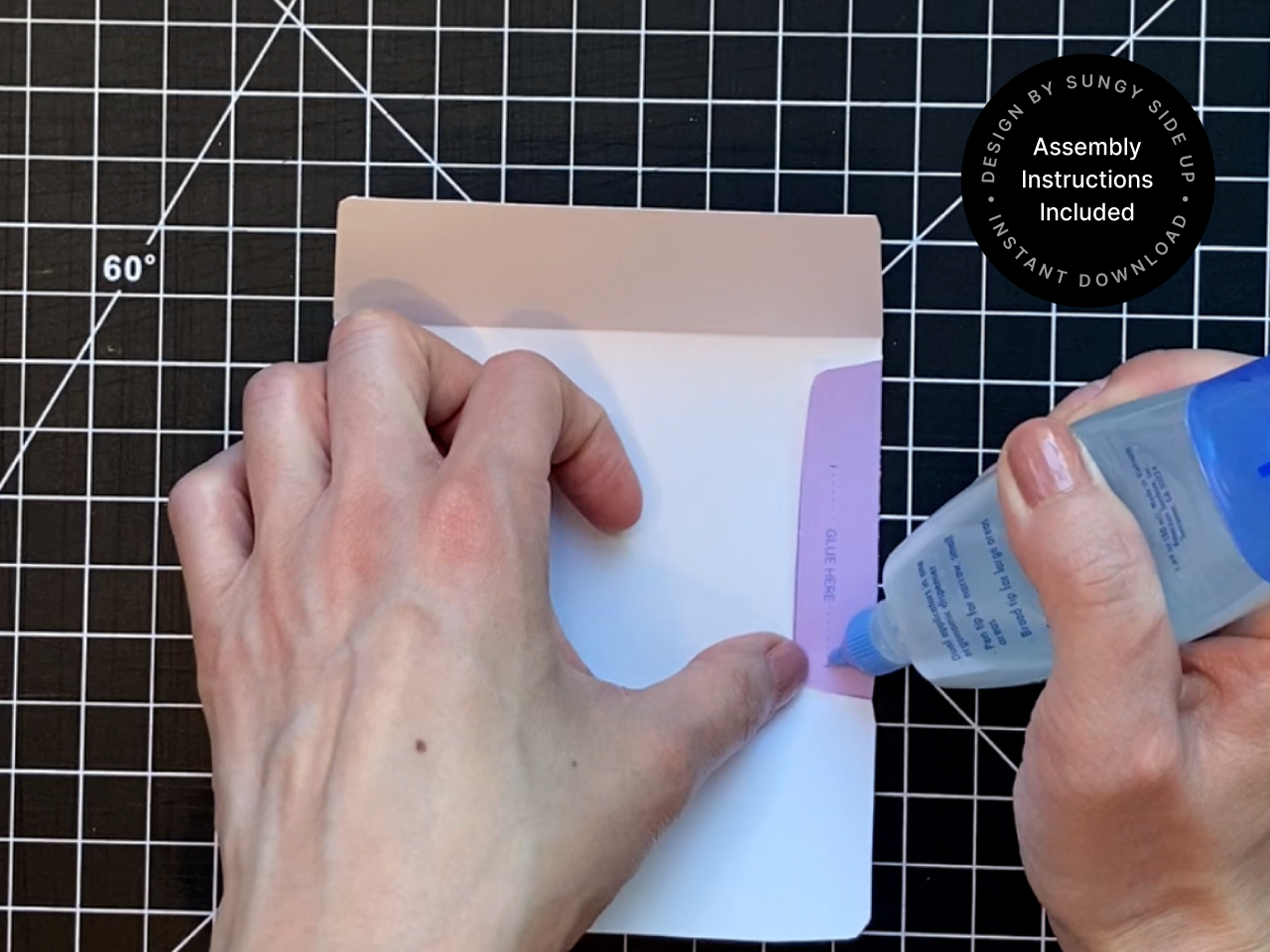 Hands applying glue to a tab while assembling a printable hippo gift card holder. This step shows part of the DIY process using an instant download template. Designed for birthdays, parties, or classroom celebrations, this printable envelope makes gift-giving fun and easy. Perfect for crafters, parents, or teachers creating their own animal-themed gift wrap at home.