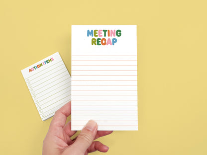 Hand holding a Meeting Recap notepad with an Action Items checklist notepad in the background on a yellow backdrop.