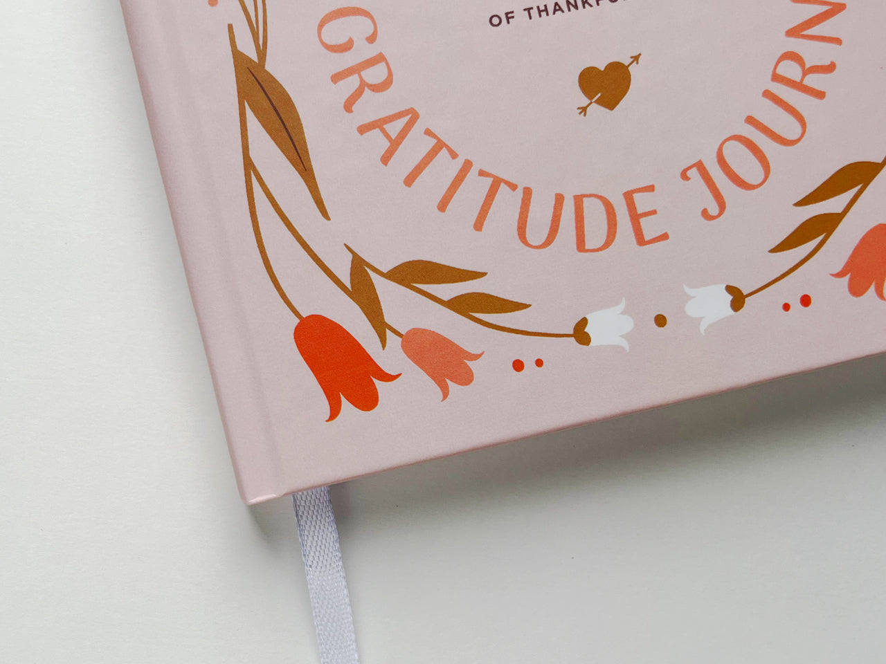 Close up of the interior pages of a personalized gratitude journal with neatly spaced dotted lines on white paper, designed for easy and organized writing. The pages are set inside a purple hardcover, with the edge of the cover slightly visible in the corner. This layout provides a clear structure for journaling, affirmations, reflections, and mindfulness exercises. The minimalist design is perfect for those who appreciate clean, simple spaces to write their thoughts and daily reflections.