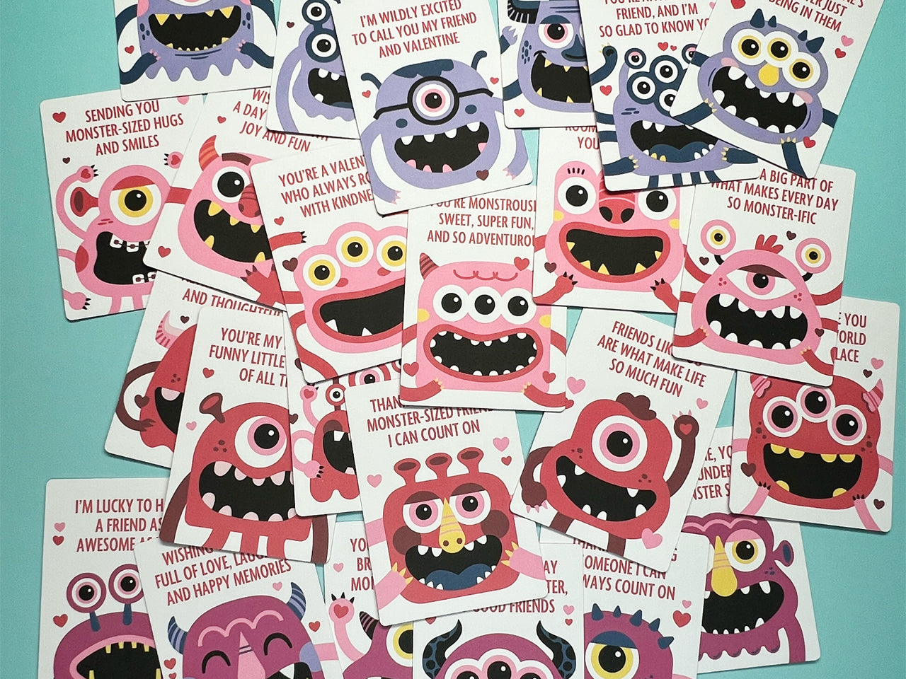 An assortment of colorful monster-themed Valentine's Day cards displayed on a turquoise background. Each card features playful monster illustrations with unique designs and cheerful messages. This set is perfect for kid classroom Valentine parties.