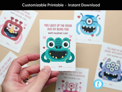 A close-up of a cute, monster-themed Valentine card with a Valentine message in red and pink. The card features a teal monster illustration surrounded by hearts. Additional cards with various designs are displayed in the background.