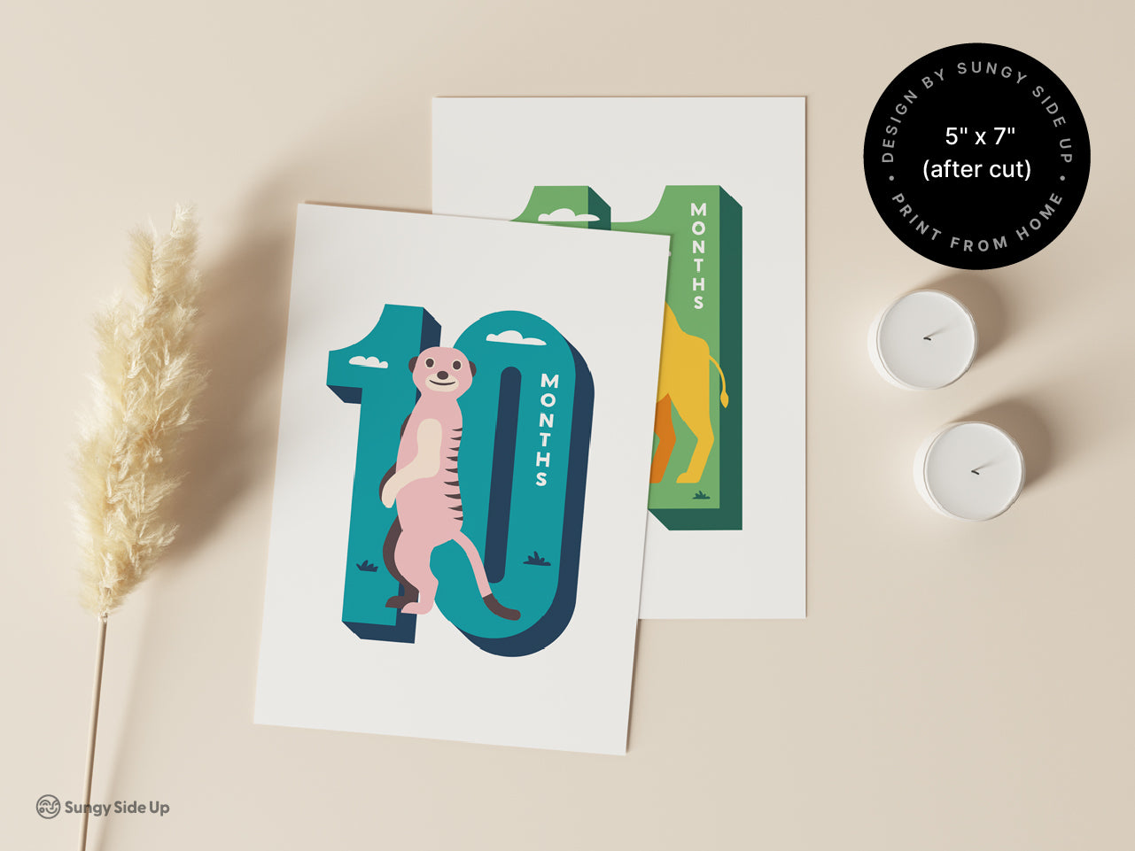 Two printable monthly milestone cards featuring a playful meerkat for 10 months and a camel for 11 months, designed by Sungy Side Up. Displayed on a beige background with decorative candles and grass, emphasizing the 5 x 7 inch size after cutting.