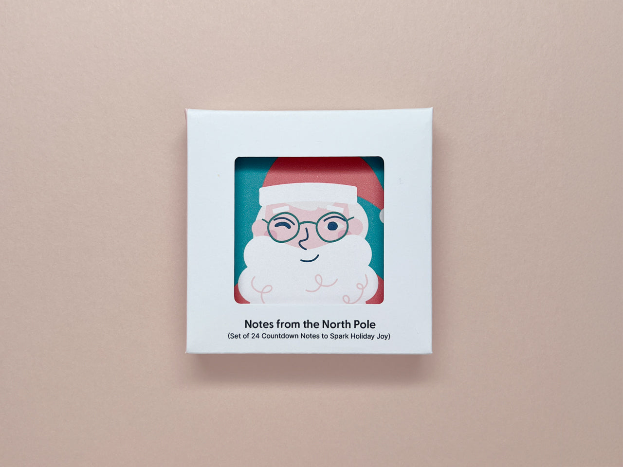 A boxed set of mini holiday notes titled "Notes from the North Pole," showcasing a Santa Claus illustration through a cut-out window on the box. The text below reads, "Set of 24 Countdown Notes to Spark Holiday Joy."