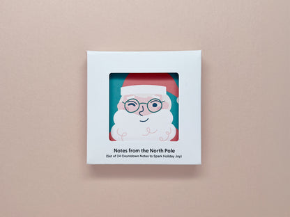 A boxed set of mini holiday notes titled "Notes from the North Pole," showcasing a Santa Claus illustration through a cut-out window on the box. The text below reads, "Set of 24 Countdown Notes to Spark Holiday Joy."