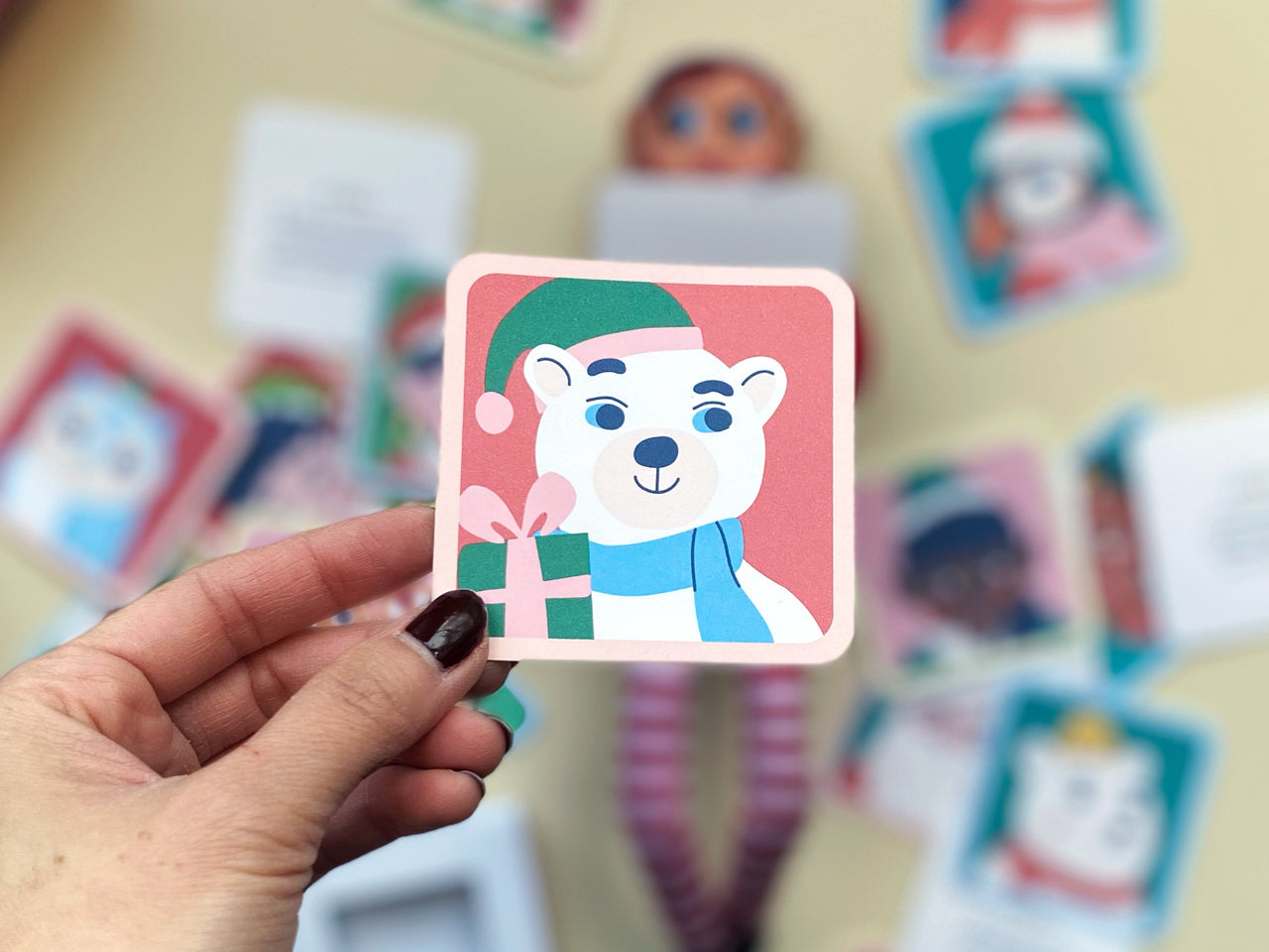 Close-up of a whimsical polar bear note card from the Notes from the North Pole set, featuring a festive holiday illustration with a green Santa hat and pink gift box. Perfect for building Christmas countdown excitement and holiday surprises.