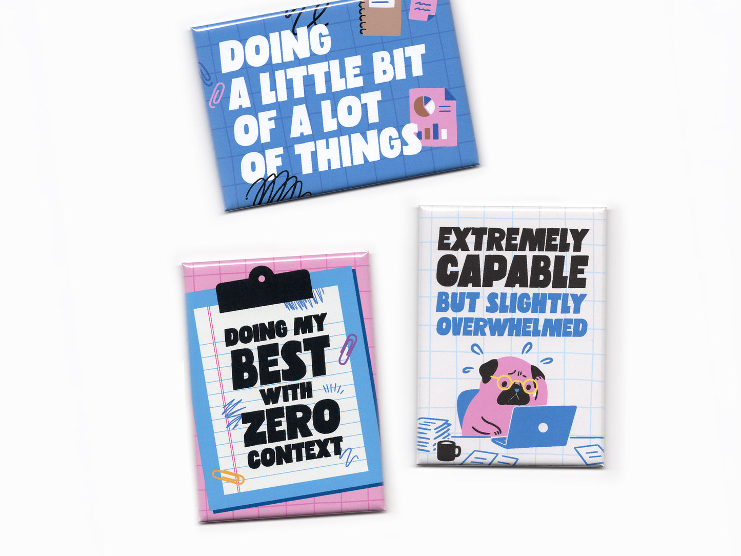 Three colorful office humor magnets arranged on a light gray background. The top blue magnet says “Doing a Little Bit of a Lot of Things” with office doodles and charts. The bottom left pink magnet resembles a clipboard and says “Doing My Best With Zero Context.” The right white grid magnet features a stressed cartoon pug at a laptop with the phrase “Extremely Capable But Slightly Overwhelmed.” The designs use bold typography, bright blue and pink colors, and playful office-themed illustrations.