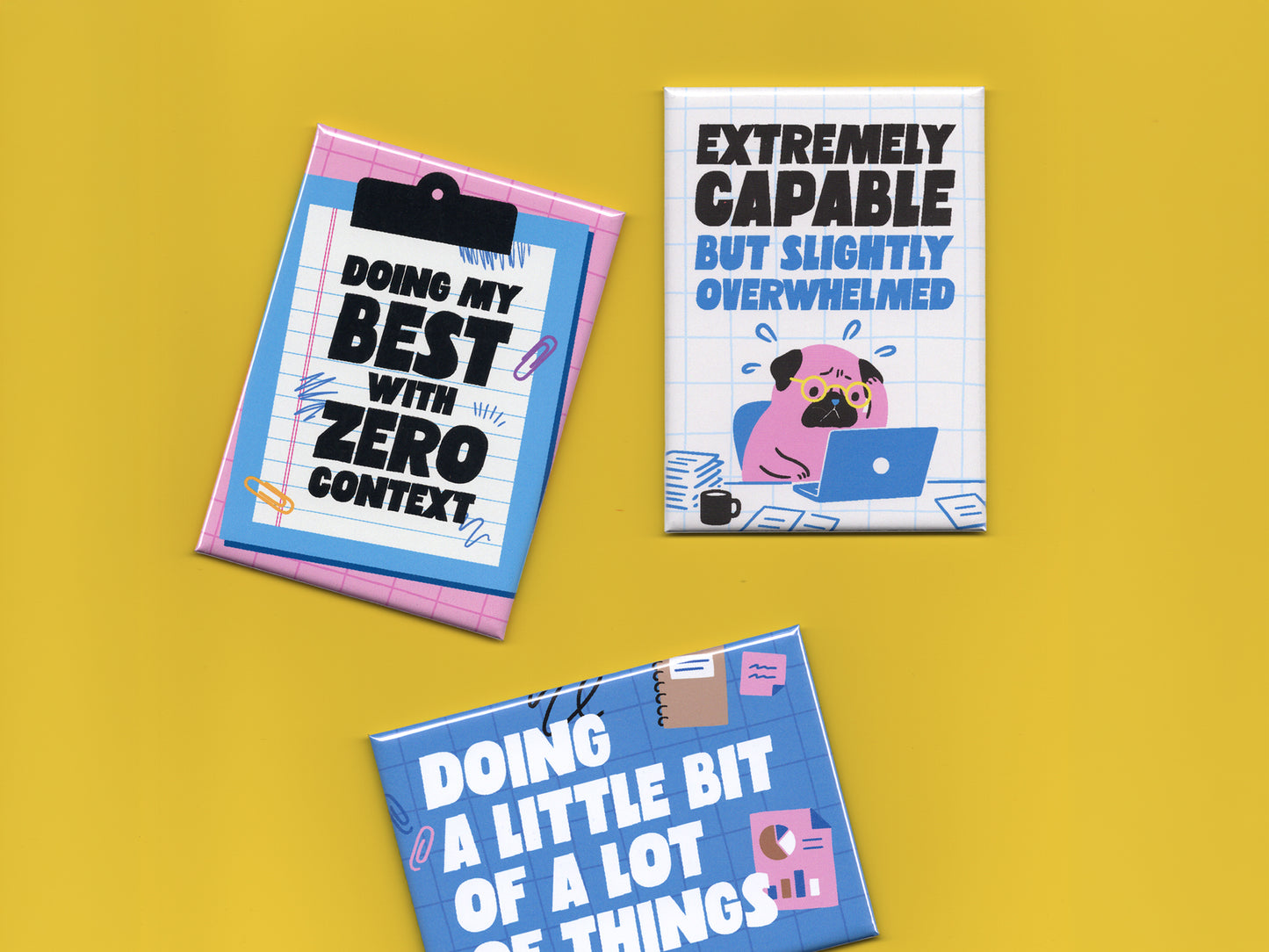 Three colorful office humor magnets displayed on a bright yellow background. The pink clipboard-style magnet says “Doing My Best With Zero Context.” The white grid magnet features a stressed cartoon pug working on a laptop with the phrase “Extremely Capable But Slightly Overwhelmed.” The blue office-themed magnet says “Doing a Little Bit of a Lot of Things” with charts, paper clips, and notebook doodles. The magnets use bold typography and playful blue and pink illustrations inspired by office life and burn