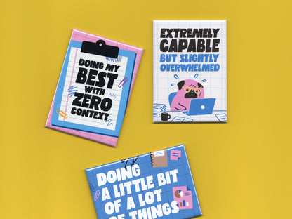 Three colorful office humor magnets displayed on a bright yellow background. The pink clipboard-style magnet says “Doing My Best With Zero Context.” The white grid magnet features a stressed cartoon pug working on a laptop with the phrase “Extremely Capable But Slightly Overwhelmed.” The blue office-themed magnet says “Doing a Little Bit of a Lot of Things” with charts, paper clips, and notebook doodles. The magnets use bold typography and playful blue and pink illustrations inspired by office life and burn