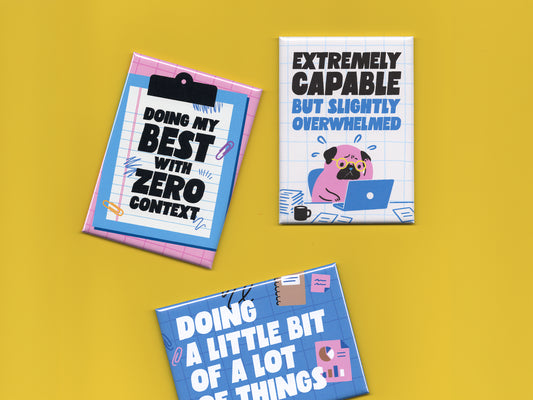 Three colorful office humor magnets displayed on a bright yellow background. The pink clipboard-style magnet says “Doing My Best With Zero Context.” The white grid magnet features a stressed cartoon pug working on a laptop with the phrase “Extremely Capable But Slightly Overwhelmed.” The blue office-themed magnet says “Doing a Little Bit of a Lot of Things” with charts, paper clips, and notebook doodles. The magnets use bold typography and playful blue and pink illustrations inspired by office life and burn