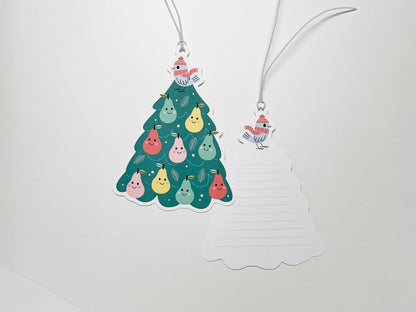A double-sided gift tag shaped like a Christmas tree, featuring a Partridge in a Pear Tree design with smiling pears and a gray bird. The back of the tag includes lined space for personalized messages, tied with a white string for easy attachment.