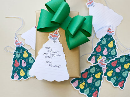 A festive Christmas gift with a green bow and a whimsical Partridge in a Pear Tree gift tag featuring space for a handwritten message. Other tags with smiling pears are scattered nearby, creating a playful and charming holiday gift presentation.
