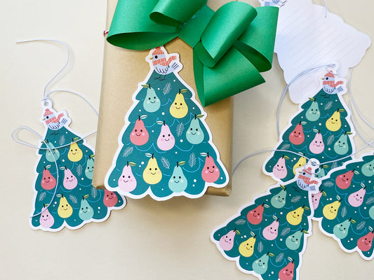 A set of colorful Christmas gift tags featuring a whimsical partridge in a pear tree design. The gift tags are shaped like Christmas trees, decorated with smiling pears in various colors, and topped with a bird wearing a red winter hat and scarf.