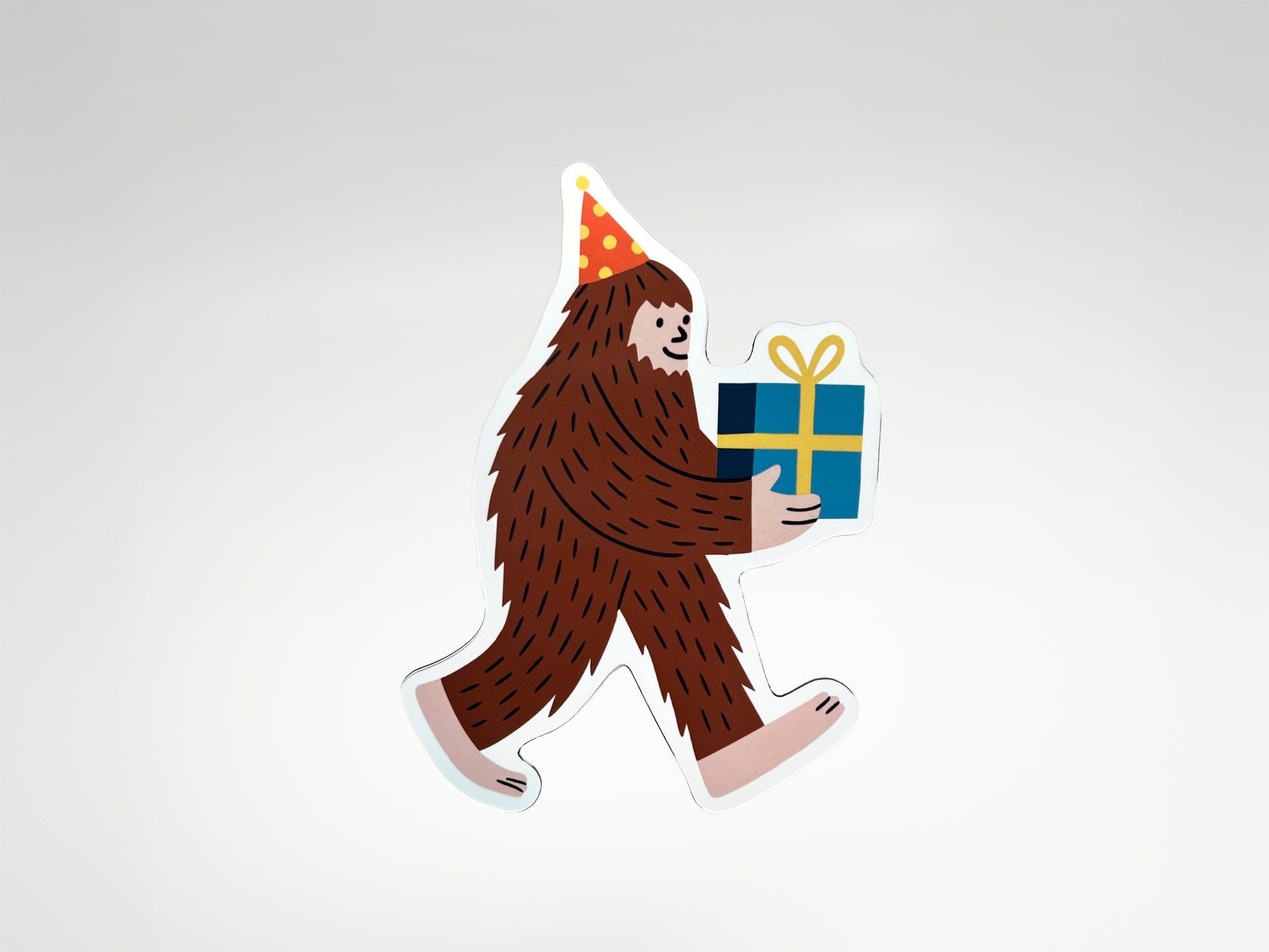 Die-cut Party Legend magnet featuring a smiling Sasquatch character wearing a red and yellow polka-dot party hat and carrying a wrapped blue gift tied with a yellow bow. This quirky Bigfoot magnet makes a unique party favor, birthday keepsake, or fun fridge decoration that adds personality to any space. Handmade and full of charm, it’s a playful gift for guests who love offbeat designs, legendary vibes, and celebrating with humor that lasts beyond the party.