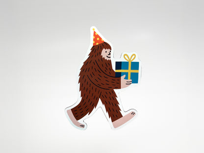 Die-cut Party Legend magnet featuring a smiling Sasquatch character wearing a red and yellow polka-dot party hat and carrying a wrapped blue gift tied with a yellow bow. This quirky Bigfoot magnet makes a unique party favor, birthday keepsake, or fun fridge decoration that adds personality to any space. Handmade and full of charm, it’s a playful gift for guests who love offbeat designs, legendary vibes, and celebrating with humor that lasts beyond the party.