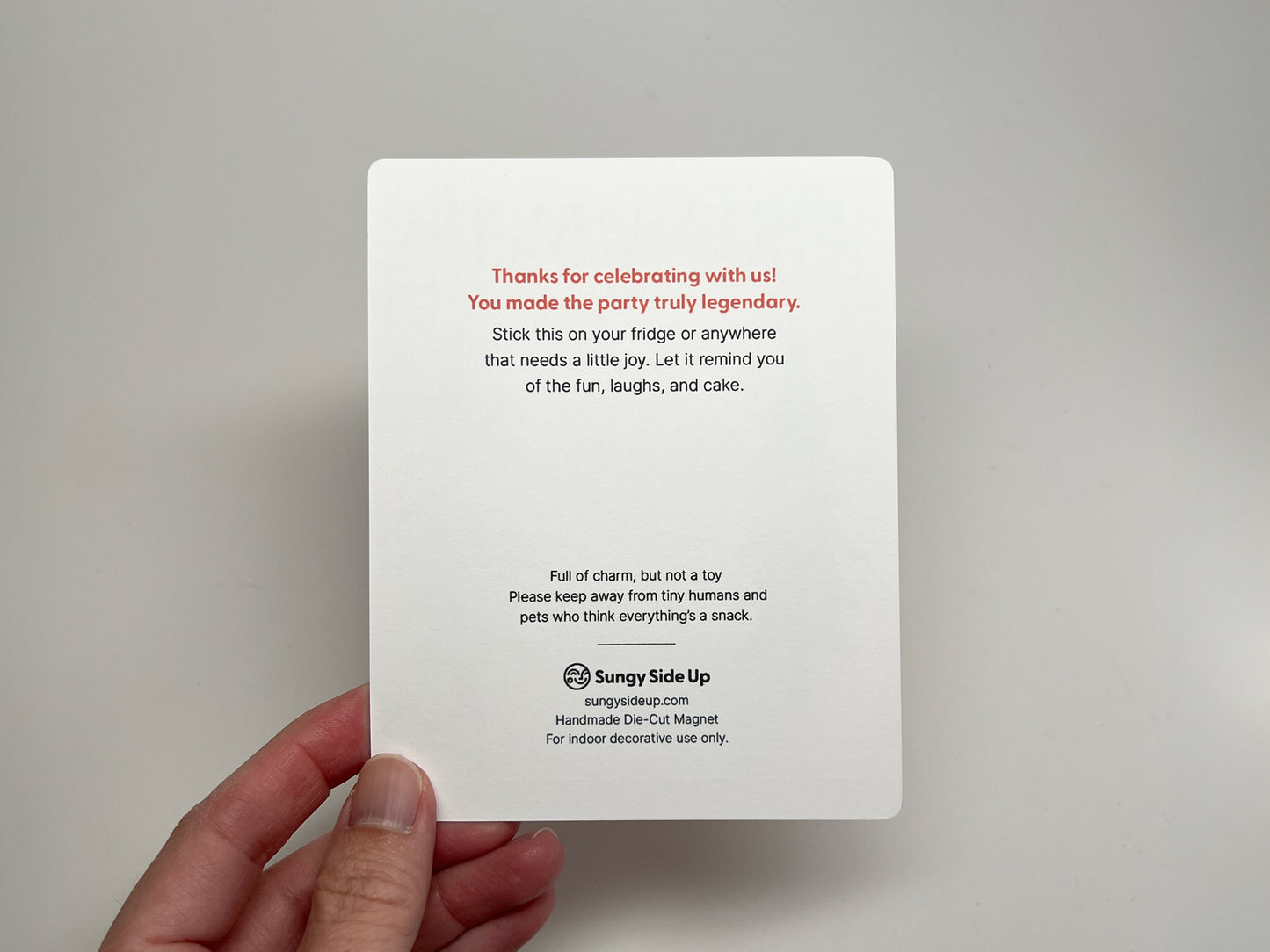 Back of the Party Legend Sasquatch magnet backing card featuring a thank you note in red and black text. It reads “Thanks for celebrating with us! You made the party truly legendary.” Includes a reminder to place the magnet on a fridge or surface for joy, along with a safety note to keep away from children and pets. Sungy Side Up branding and product details are printed at the bottom.
