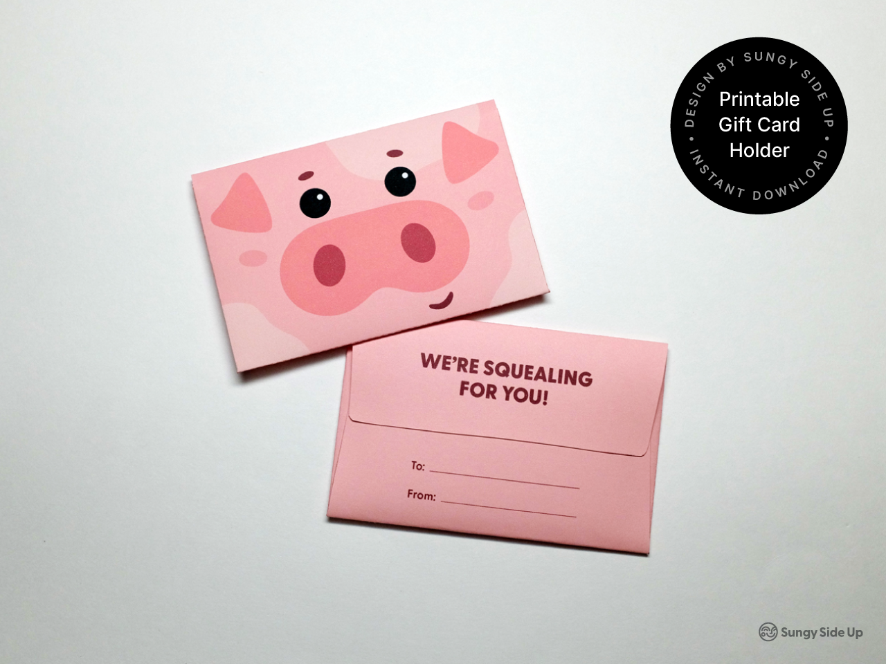 A printable pig gift card holder with a pink pig design, featuring a smiling cartoon pig face on the front and a "We're Squealing for You!" message on the back with a To/From section for gift-giving. This DIY animal-themed card holder is an instant digital download that includes easy-to-follow assembly instructions. Perfect for birthdays, kids’ parties, and creative gifting ideas for animal lovers.
