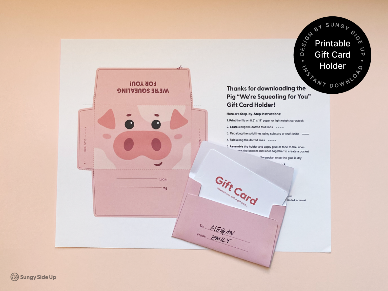 A pink printable pig gift card holder with a cute cartoon pig design and a To/From section is shown assembled next to the printed template sheet and step-by-step instructions. The holder includes a handwritten To/From gift message and a white gift card. This instant download template is a fun and easy DIY craft for birthdays, animal-themed parties, and thoughtful gift-giving. Includes simple assembly instructions.