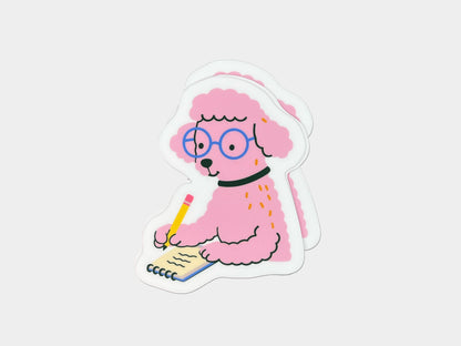 Three matte die-cut vinyl stickers stacked together, each featuring a pink illustrated poodle wearing round blue glasses and a black collar while writing in a small spiral notebook with a yellow pencil. The poodle has fluffy textured fur and a calm, focused expression. Each sticker has a white border and is displayed on a white background.