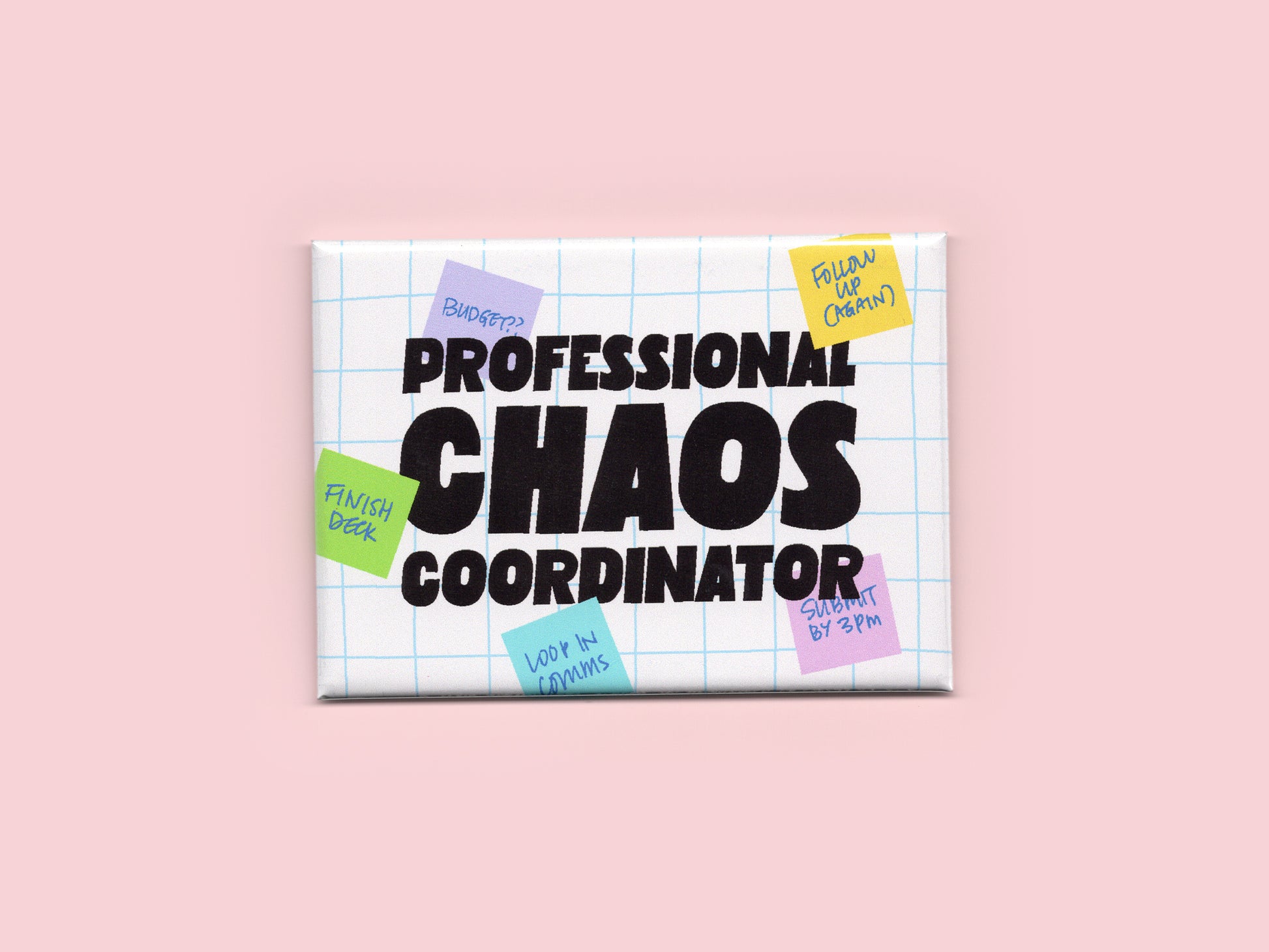 Rectangular white magnet with a light blue grid background and bold black text that reads “Professional Chaos Coordinator.” Colorful sticky notes with handwritten reminders surround the text. The magnet is displayed against a light pink background.