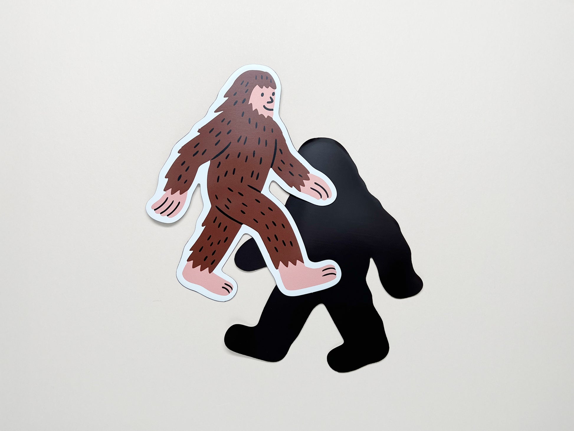 Front and back view of die-cut Bigfoot magnet by Sungy Side Up; features a quirky Sasquatch design on the front and strong black magnetic backing—fun handmade gift for cryptid fans, outdoor lovers, and fridge décor collectors.