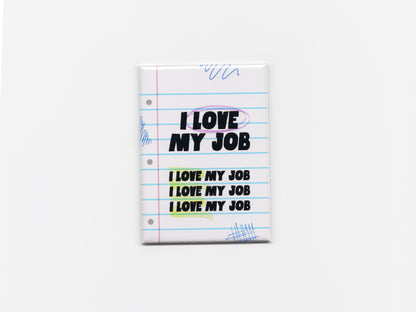 Square fridge magnet centered on a plain light background, designed like a sheet of lined notebook paper with blue horizontal lines and a pink margin. The magnet reads “I LOVE MY JOB” in bold black text at the top, with the phrase repeated three times below in smaller text. The word “LOVE” is circled in purple, and the repeated lines are highlighted in soft yellow and green. Blue pen-style doodles appear in the corners, and the magnet has a smooth, glossy finish with slightly rounded edges.